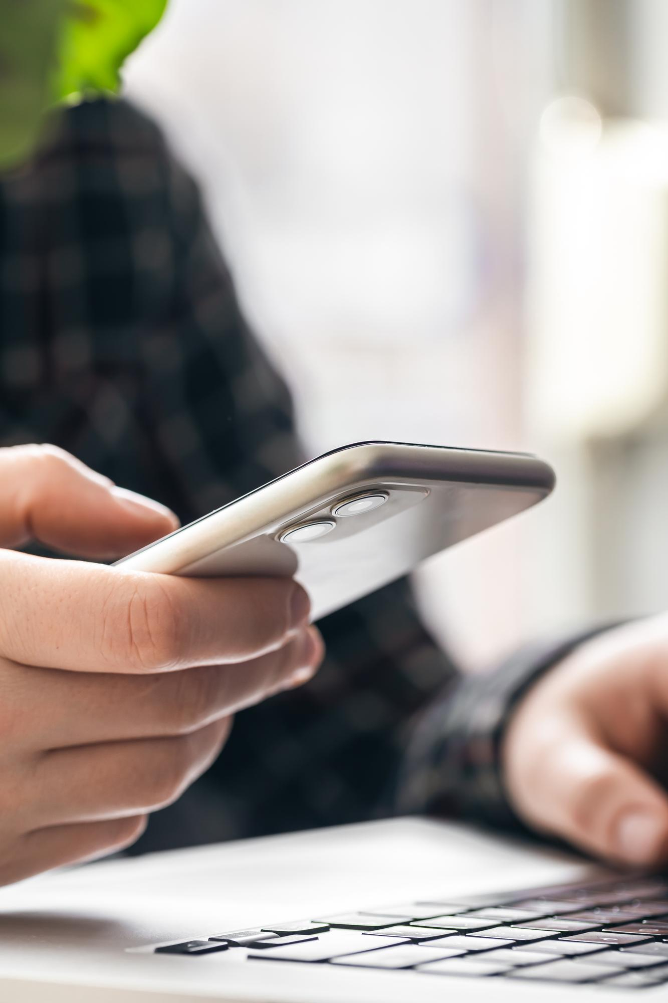 Smartphone in der Hand bei der Terminvereinbarung als Symbol für den ersten Schritt in die Psychotherapie und den Ablauf der Kontaktaufnahme