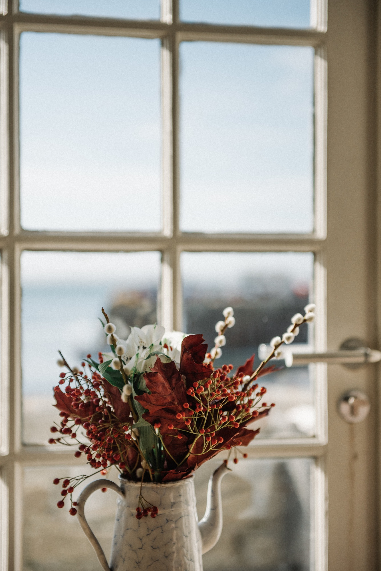 Vase mit Blumen im sanften Sonnenlicht am Fenster – ruhige, helle Atmosphäre in einer Praxis für Psychotherapie in Berlin
